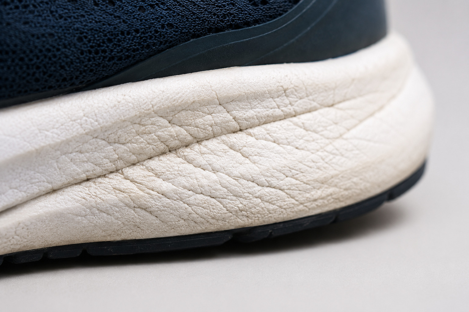 Close up of compression creases forming along the sidewall of a running shoe midsole